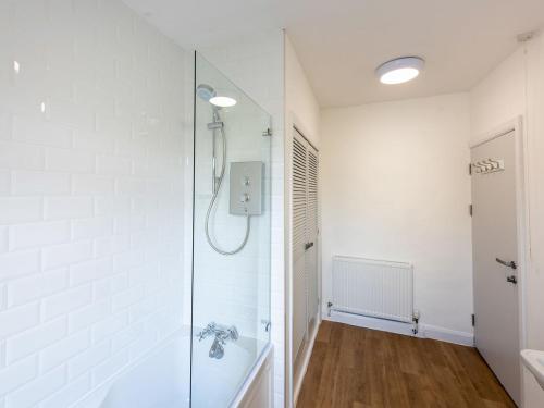 a bathroom with a shower with a glass door at The Farmhouse in High Catton