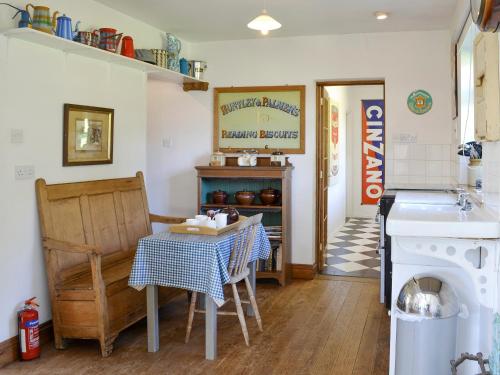 a kitchen with a table and a stove and a sink at Malthouse Barn in Hastingleigh