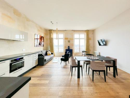 ボルドーにあるMagnifiques Appartements sur les Quais de Bordeauxのキッチン、リビングルーム(テーブル、椅子付)