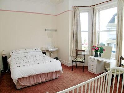 a bedroom with a bed and a desk and window at Mayflower in Cromer