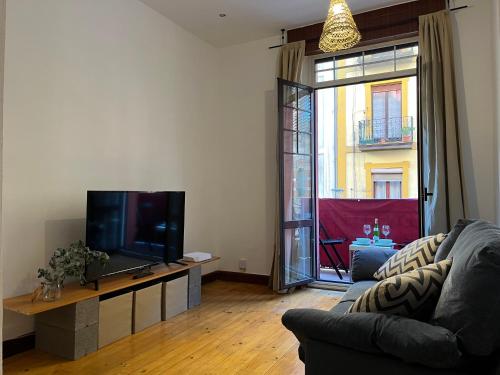 a living room with a couch and a flat screen tv at Bonito apartamento muy céntrico in Bilbao