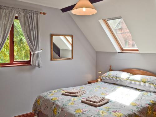 a bedroom with a bed with two towels on it at The Coach House in Swanwick