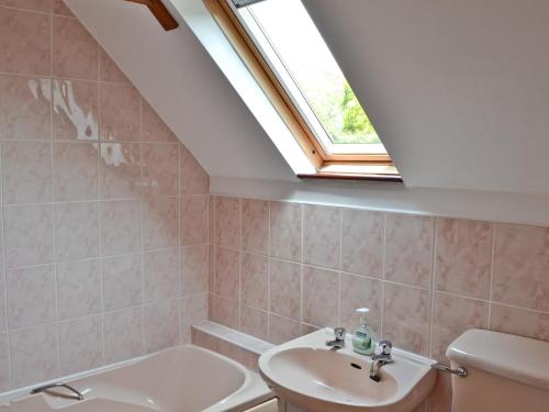 łazienka z umywalką i oknem dachowym w obiekcie The Coach House w mieście Swanwick
