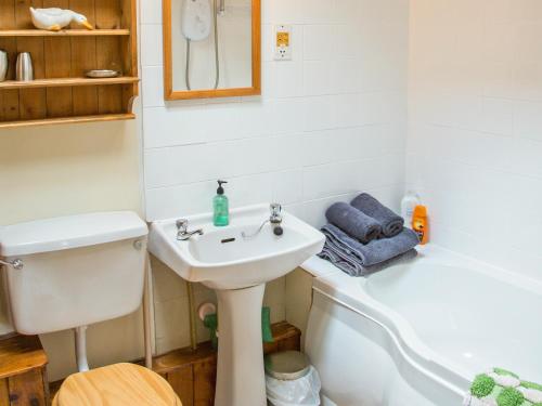 a bathroom with a sink and a toilet and a bath tub at East Granary - 28956 in Eye