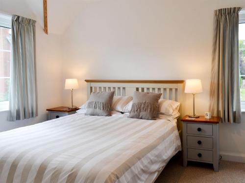 a bedroom with a large bed with two lamps at One Parkhayes in Woodbury