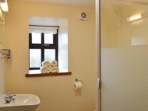 a bathroom with a sink and a window with towels at Ger Yllan in Cross Inn