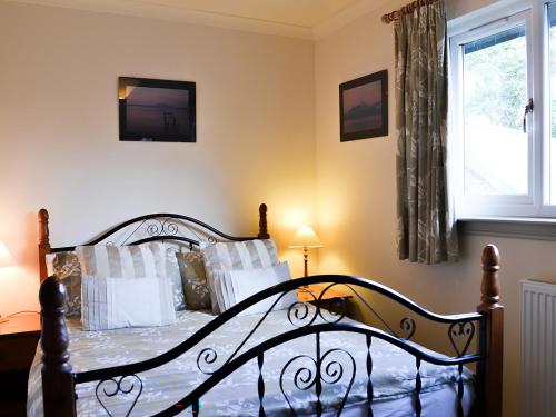 een slaapkamer met een bed met witte kussens en een raam bij Tigh A Vullin - S4628 in Ardfern