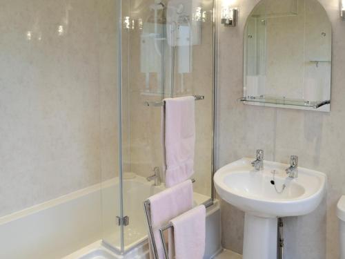 a bathroom with a sink and a glass shower at Birch Cottage- 15841 in Catcleugh
