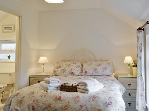 1 dormitorio con 1 cama con toallas en Sparrows Nest en Sampford Arundel