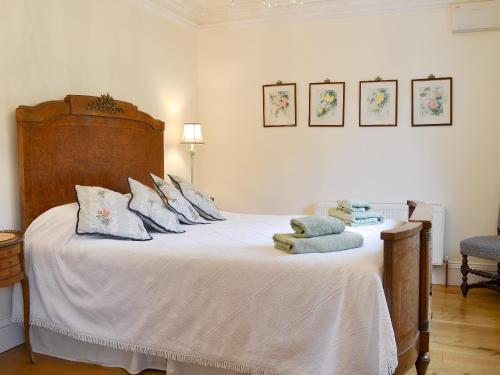 a bedroom with a bed with white sheets and pillows at Garden Cottage in Westleigh