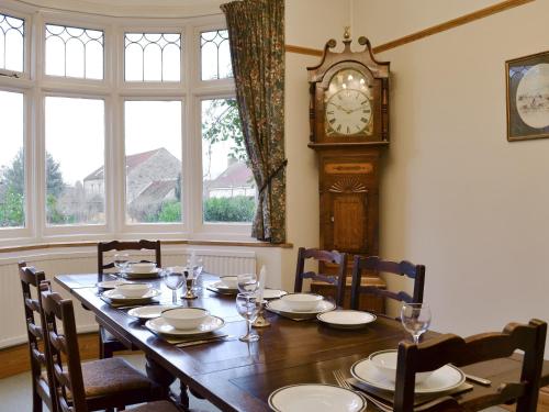 a dining room with a table and a grandfather clock at Colville House in Helmsley