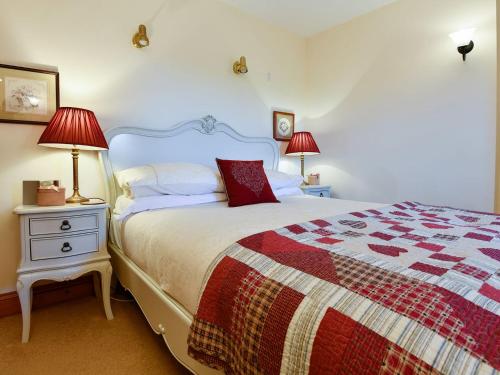 a bedroom with a large bed and two lamps at Ash Tree Cottage in Bassenthwaite