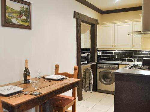 a kitchen with a wooden table with a bottle of wine at The Cottage in Blackwood