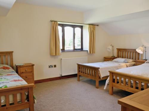 a bedroom with two beds and a window at The Stable in Parkham