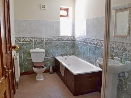 a bathroom with a toilet and a tub and a sink at The Stable in Parkham