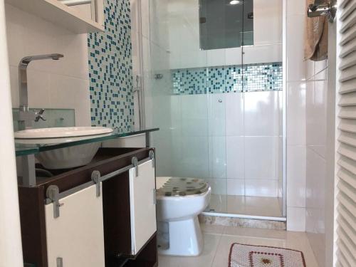 a bathroom with a toilet and a sink and a shower at FORTE DA PRAIA in Cabo Frio