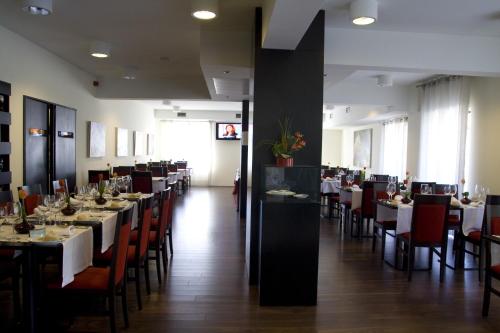 a dining room with long tables and chairs with white tablecloths at Paredes Hotel Apartamento in Paredes