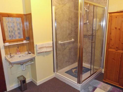 a bathroom with a shower and a sink at Gladstone Cottage in Castletown
