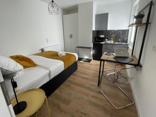 1 dormitorio con cama y mesa con ordenador portátil en moor-home Studio Apartment, en Ganderkesee