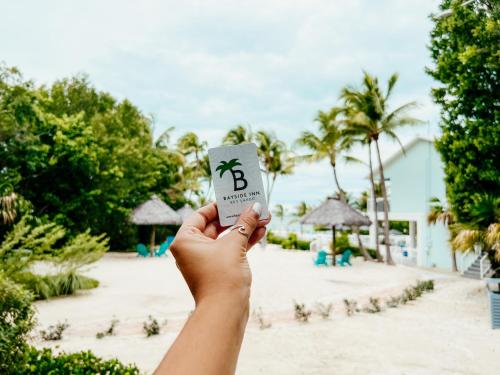 a person holding up a paper cup with a dollar sign on it at Bayside Inn Key Largo in Key Largo