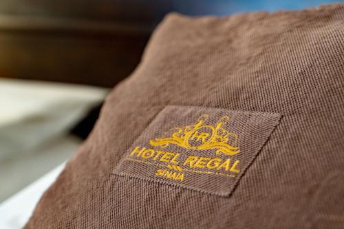 um close-up de uma camisa castanha com um logótipo real do hotel em Hotel Regal em Sinaia