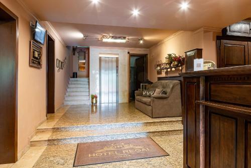 a hotel room hallway with a couch and a hotel neoser at Hotel Regal in Sinaia