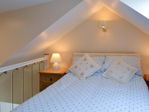 a bedroom with a blue bed with pillows on it at Freya Cottage in Flamborough