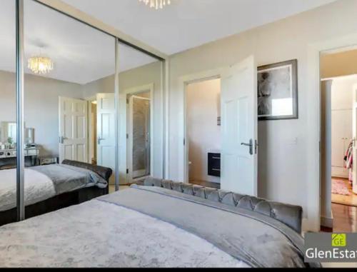 een slaapkamer met 2 bedden en een grote spiegel bij Bridgeview in Carrigart