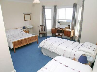 a bedroom with two beds and a desk at Sky Lark in Cromer