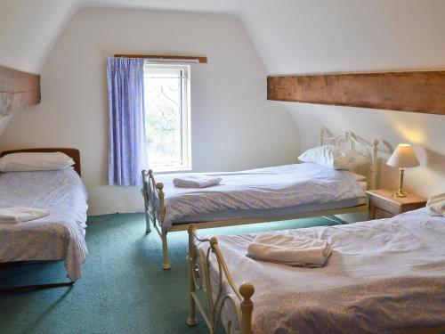 a bedroom with two beds and a window at Somersal Farmhouse in Somersal Herbert