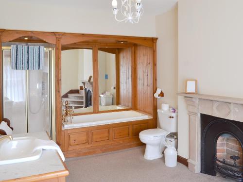 een badkamer met een bad, een toilet en een wastafel bij Somersal Farmhouse in Somersal Herbert