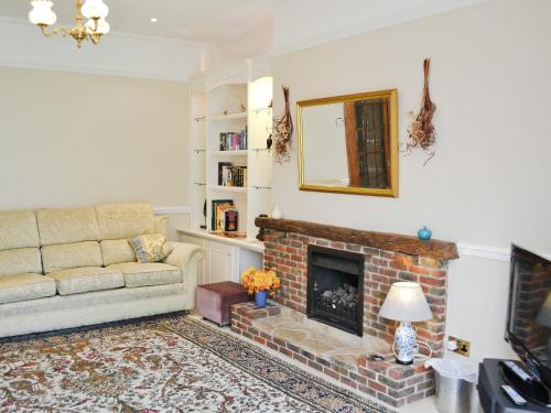 uma sala de estar com um sofá e uma lareira em Ivy Cottage em Westgate on Sea