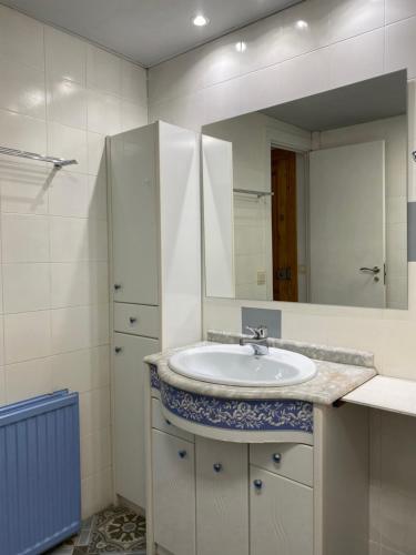 y baño con lavabo y espejo. en Apartamento Arce II en al Valle de Benasque, en Castejón de Sos