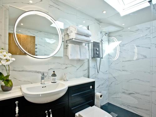 ein weißes Badezimmer mit einem Waschbecken und einem Spiegel in der Unterkunft Woodland View Lodge in Hawley Bottom
