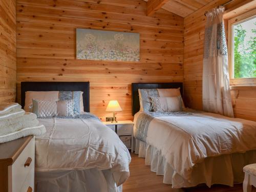 BanavieにあるCruachan Log Cabinのログキャビン内のベッドルーム1室(ベッド2台付)
