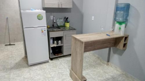 cocina con nevera blanca y mesa de madera en shalom salomón- punta iglesia en Paso de la Patria