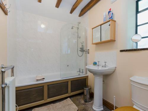 ein Bad mit einer Dusche und einem Waschbecken in der Unterkunft Highbury Cottage in Hathersage