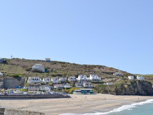 a group of houses on a hill next to the beach at Coombe End Cottage in Carnbrea