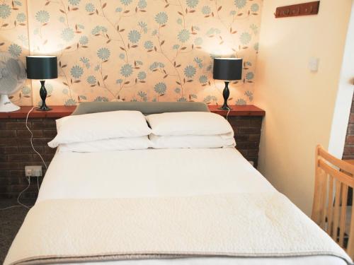 a bedroom with a bed with two lamps on the wall at Ottery Tor - Ukc1925 in Stokeinteignhead