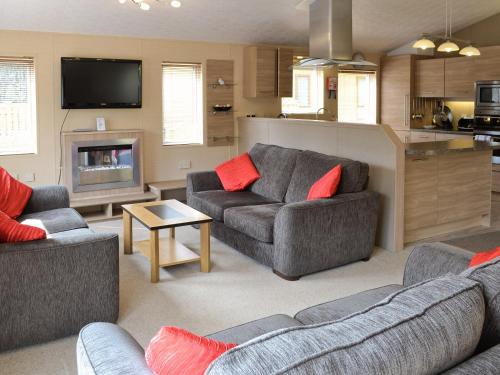 a living room with two couches and a tv at Hazel Cottage - E4786a in Brough