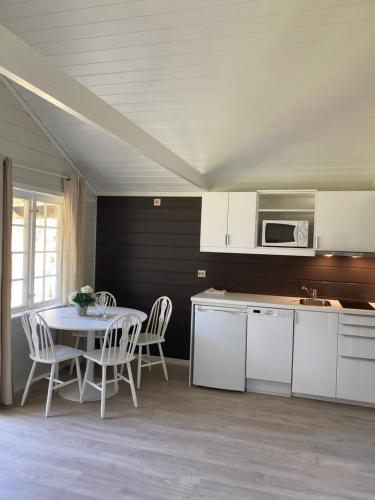 uma cozinha com uma mesa e cadeiras e um micro-ondas em Nygård Camping em Hjelle