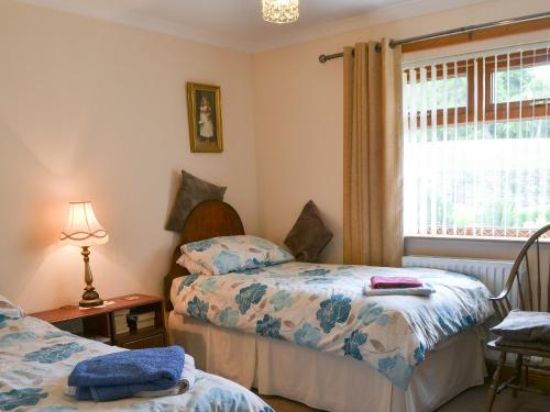 a bedroom with two beds and a window at Riverside in Annan