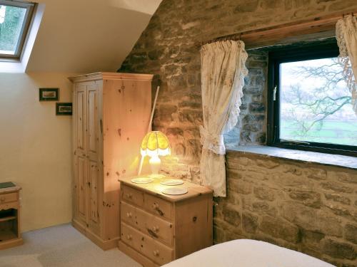 Ladycroft Barn في بامفورد: غرفة نوم بسرير وخزانة ونافذة