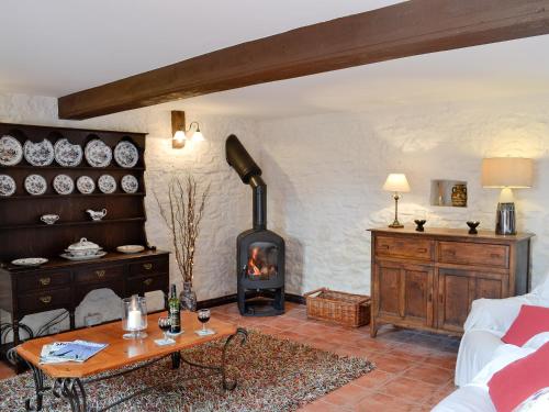 a living room with a wood stove in a room at The Stables in Woolaston