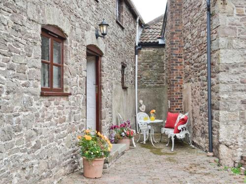 an alley with a table and chairs in an old building at The Stables in Woolaston