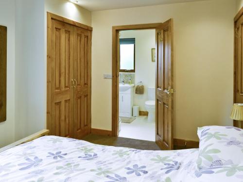 a bedroom with a bed and a bathroom at Hawthorn Lodge in Burgh le Marsh