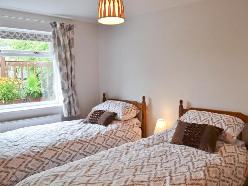 two twin beds in a bedroom with a window at Woodview Lodge in Barlow