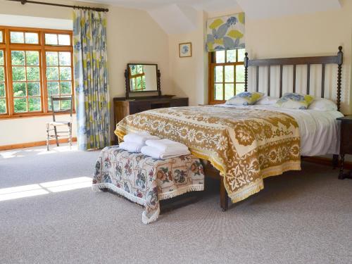 a bedroom with a large bed and a television at Cae Ocyn in Dwyran