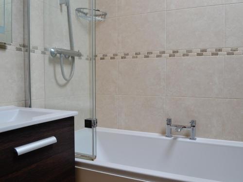 a bathroom with a shower and a sink and a tub at Apple Tree Cottage in Blockley