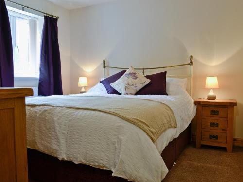 a bedroom with a large bed with two lamps at Bwthyn Bwlch in Denbigh